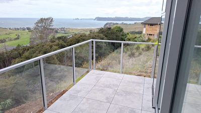 Frameless glass balustrade on a tiled deck with a sea view