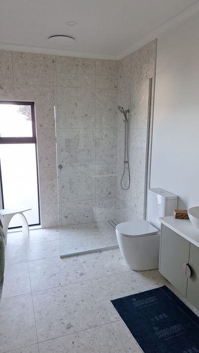Frameless glass shower screen in a tiled bathroom