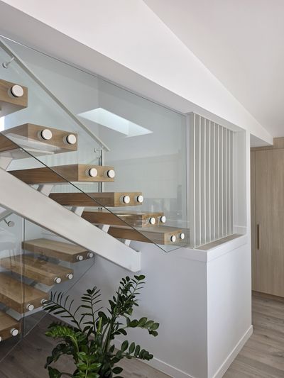 The completed floating timber staircase with glass balustrade, matching the 3D render