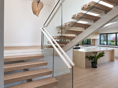 Frameless glass balustrade on a floating staircase in an open-plan living space, Whangamata