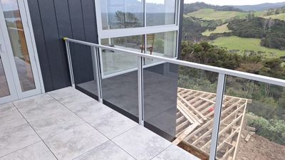 Glass balustrade on a tiled patio with a sea view