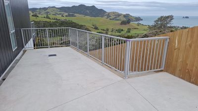 Glass and aluminium balustrade on a timber deck with a coastal view