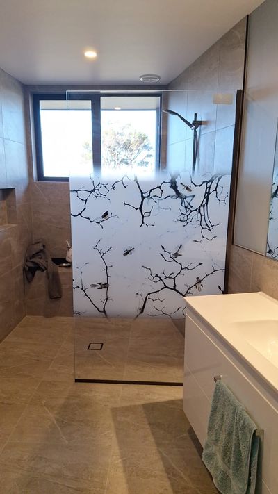 Printed frameless shower screen with a branch design