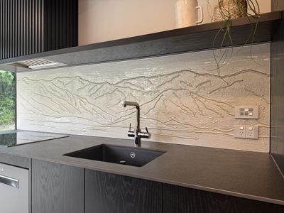 Textured glass splashback with a mountain relief design